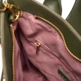 Bolso tipo tote bag de mujer, color verde militar, con cuerpo de lona y solapa frontal de cuero sintético (PU) con cierre a presión. Posee doble asa corta y correa larga desmontable y regulable. Incluye logo XL grabado en la solapa.