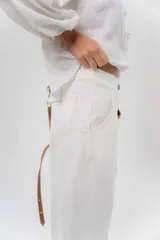 Pantalón de gabardina de algodón color negro, con calce barrel, cintura media baja, recortes de diseño y detalle de botones en el ruedo para ajustar el volumen.