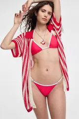 Top de bikini de diseño triangular, color fucsia con ribetes blancos en los bordes y tirantes ajustables.