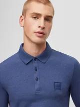 Remera polo de manga larga azul de algodón, corte slim fit, con cuello clásico y tapeta de dos botones. Incluye un pequeño bolsillo cuadrado en el pecho con el logo de la marca. 