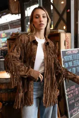 Chaqueta de gamuza marrón con diseño de flecos en la parte delantera y las mangas, corte tipo camisa y cierre frontal de botones.