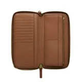 Billetera tipo continental de Marc Jacobs, confeccionada en cuero color marrón, con cierre perimetral metálico dorado. El interior cuenta con múltiples ranuras para tarjetas, compartimentos para billetes y un bolsillo central con cierre.