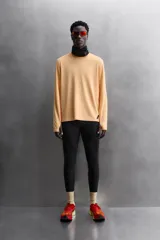 Camiseta deportiva color durazno de manga larga con orificios para los pulgares.