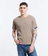 Remera muscle de hombre, color marrón claro, confeccionada en media malla, de cuello redondo y manga corta.