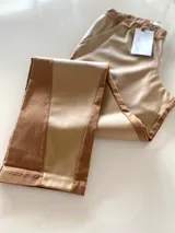 Pantalón combinado tostado, confeccionado con un panel frontal de cuerina elástica en tono camel y un panel posterior de gabardina con spandex en tono tostado. Presenta una cintura elastizada para mayor comodidad y costuras a la vista en contraste.