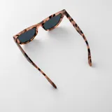 Lentes de sol con armazón de carey en tonos marrones y negros, y cristales degradados. Tienen un diseño moderno y versátil.