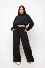 Conjunto deportivo de dos piezas compuesto por un buzo cropped de cuello alto con cordón ajustable y un pantalón estilo clochard de corte holgado con cintura elástica regulable y bolsillos laterales. Ambas prendas están confeccionadas en tejido técnico ligero con acabado suave al tacto.