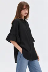 Camisa de algodón negra con cuello camisero, cierre frontal con botones y mangas 3/4 terminadas en volados.