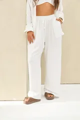 Pantalón blanco de tiro alto, de corte holgado y pernera ancha, con cintura elástica fruncida y cordón ajustable delantero.