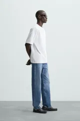 Camiseta color arena de algodón compacto, corte recto, cuello redondo y mangas cortas.