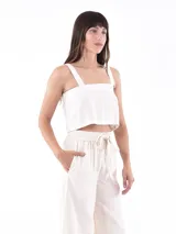 Top corto color blanco roto, de tejido con textura, con tirantes anchos y escote cuadrado.