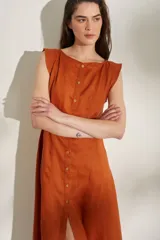 Vestido largo sin mangas de lino color naranja, con escote bote y hilera de botones frontales que forman una abertura en la falda.