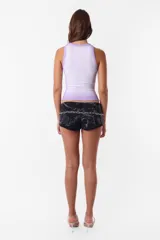 Microshort de gabardina de tiro bajo y corte slim fit. Presenta costuras en contraste color rojo, cierre metálico frontal y presillas largas en la cintura. La prenda cuenta con un proceso de sobreteñido y lavado artesanal que le otorga un aspecto desgastado único.