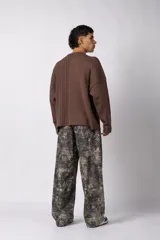 Sweater de punto color blanco con diseño de textura combinada, presentando un lado liso y otro con tejido trenzado. Posee cuello redondo, mangas largas y un corte relajado.