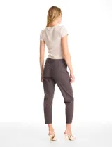 Pantalón de corte crop, color gris, con diseño de cinco bolsillos, cierre frontal con botón y ruedo irregular con terminación desflecada.