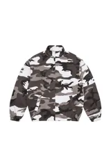 Campera tipo Harrington de Supreme con estampado de camuflaje en tonos blanco, gris y negro. Presenta cuello alto, cierre frontal completo, bolsillos laterales y puños elásticos.