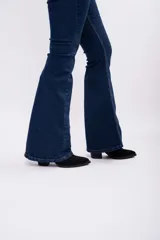 Jean de corte oxford y tiro alto en color azul oscuro, con diseño de pierna ajustada hasta la rodilla y botamanga acampanada.