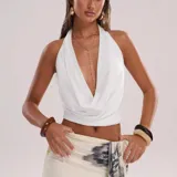 Top blanco de diseño cruzado tipo halter con escote pronunciado en V.