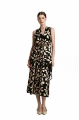 Túnica sin mangas confeccionada en tul negro transparente, con diseño bordado de flores en tonos dorados y escote en V.