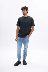 Pantalón de jean celeste de corte slim, con efecto lavado, bolsillos clásicos y cierre frontal de botón y cremallera.