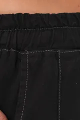 Pantalón negro de pierna súper amplia, confeccionado en denim fino y liviano con caída fluida. Tiene cintura elastizada con lazo regulable, bolsillos laterales y pinzas en la delantera.