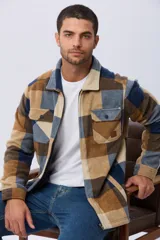Campera leñadora de tejido polar con estampado a cuadros en tonos marrones, beige y azules. Presenta cierre frontal, cuello camisero, bolsillos superiores con solapa y bolsillos laterales.