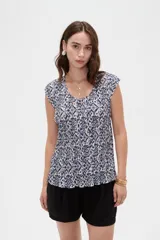 Blusa de poliéster sin mangas con cuello redondo y estampado geométrico en tonos marrones y blancos, de corte holgado y diseño fluido.