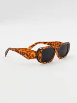 Lentes de sol con montura rectangular de carey y lentes oscuros.