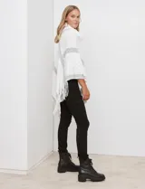 Poncho tejido negro con textura, cuello alto de velour negro y terminación con flecos largos en el ruedo.