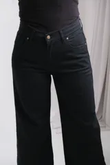 Pantalón de jean negro de corte recto y tiro alto, con cierre frontal de botón y cremallera, y bolsillos laterales.