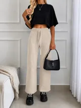 Pantalón negro de lanilla con brillos plateados dispersos, tiro alto con cintura elástica y cordón ajustable, de corte recto y holgado.