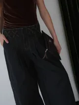 Sobre tipo cartuchera de lona con estampado de camuflaje y terminaciones en cuero marrón.