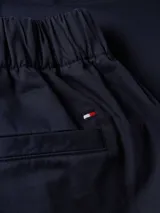 Pantalón de corte cónico Tommy Hilfiger, modelo 1985 Collection, color azul marino. Confeccionado en mezcla de algodón orgánico, con cintura elástica, cierre de botones y bolsillos traseros de ojal.