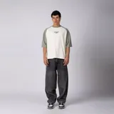 Remera de algodón con mangas raglán color verde militar y cuerpo color crudo, con cuello redondo y diseño estampado en el pecho con el texto 'ART DEPT. VCP'.