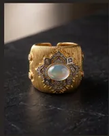 Anillo ancho de bronce con baño de oro, diseño texturizado con aplique central en forma de flor con circonias engarzadas y piedra natural ovalada.