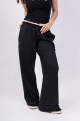 Pantalón de jogging de corte recto y tiro alto, color beige, con cintura elástica y logo bordado pequeño en la parte superior.