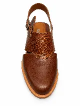 Zapato destalonado de cuero marrón con puntera cerrada, detalles de textura grabada en la capellada y tira ajustable con hebilla en el talón, con taco bajo y ancho.