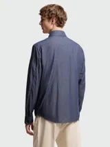 Camisa Moncler de jean azul oscuro, de manga larga, con cierre frontal de botones a presión, cuello clásico y dos bolsillos delanteros con solapa y botón.