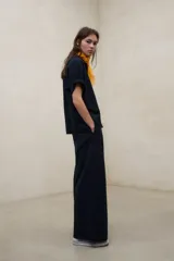Camisa negra de manga corta con tejido de textura seersucker, corte oversize, cuello camisero y cierre frontal con botones.