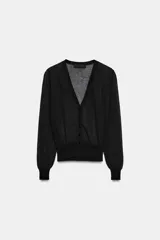Chaqueta de punto semitransparente con escote en pico, manga larga y cierre frontal con botones. Presenta puños y cintura acanalados.