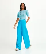 Pantalón modelo pantalona de corte amplio, confeccionado en una mezcla de viscosa y lino. Presenta cintura con botón, cierre de cremallera y bolsillos laterales.