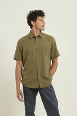 Camisa sport de manga corta, confeccionada en una mezcla de lino y algodón. Presenta cuello clásico, cierre frontal con botones de coco y un bolsillo aplicado en el pecho.