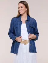 Sobrecamisa azul de denim de algodón liviano, con cuello camisero, cierre frontal de botones, bolsillos con solapa en el pecho y cordón ajustable en la cintura.