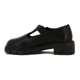Zapatos guillerminas de cuero sintético negro, con correa sobre el empeine y hebilla metálica dorada. Plataforma con suela track.