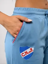 Pantalón de piqué recto color azul marino, con cintura elástica y cordón ajustable. Presenta el escudo del Club Nacional de Football en el muslo izquierdo y el logo de Umbro en el muslo derecho.