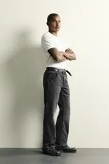 Jeans flare fit de denim de algodón en color celeste con lavado efecto desgastado. Presentan diseño de cinco bolsillos, tiro medio, cierre frontal con cremallera y botón, y bajo con acabado irregular.