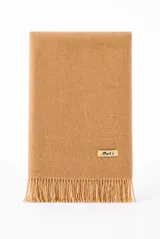 Bufanda de tejido suave en color tostado, con flecos en los extremos y una pequeña placa metálica dorada grabada con el logotipo de la marca.