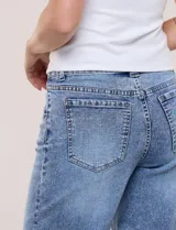 Jean wide leg de tiro medio, marca DJEANS, en tono azul claro con efecto acid wash. Presenta pretina con pasadores, cierre y botón, bolsillos delanteros inclinados y bolsillos traseros aplicados.