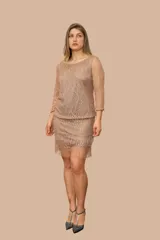 Vestido corto de encaje color beige con hilos dorados y flecos en el ruedo.