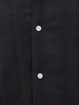 Camisa negra de algodón con cuello resort, manga corta y cierre de botones. Tejido de sarga con textura. Marca Jack & Jones.